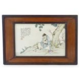 A Chinese porcelain plaque decorated with a seated elder / scholar beneath a tree, with Oriental
