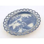 A blue and white dish of oval form with reticulated border decorated with a seascape scene with