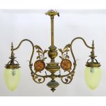 An Art Nouveau brass twin branch pendant light decorated with copper roundels depicting a figure