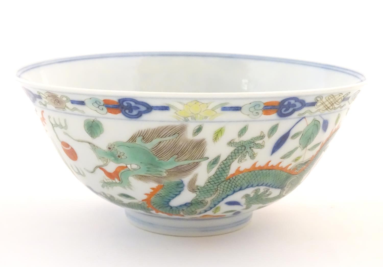 A Chinese bowl with dragon and flaming pearl detail, with flowers, foliate and stylised clouds.