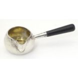 A Victorian silver brandy saucepan with spout, gilded interior and ebonised handle. Hallmarked
