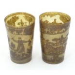 Two 19thC horn beakers with etched decoration depicting naive hunting landscape scenes with figures,