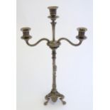A Victorian silver plate three branch candelabra, with engraved armorial to base, lion's paw feet,