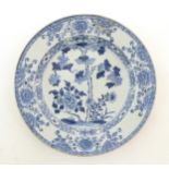 A Chinese blue and white plate decorated with flowers and foliage. With stylised motifs to