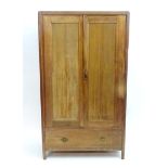 An early 20thC walnut 'Maple & Co' wardrobe with two doors opening to show hooks and a hanging rail,