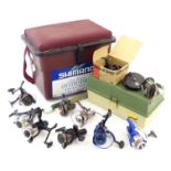 Fishing: a Shimano fishing seat box containing a collection of fixed spool fishing reels,