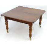 A late 19thC mahogany dining table with a moulded top above four large turned tapering legs
