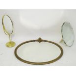A gilt framed oval mirror together with a brass mirror on stand, and a bevelled mirror. Please