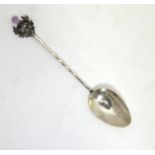 A white metal teaspoon with thistle decoration, stamped JF Please Note - we do not make reference to