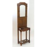 An early 20thC mahogany hall stand with a central bevelled mirror surrounded by ogee mouldings,