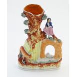 A Staffordshire pottery flat back bud vase depicting a girl on a bridge next to a tree with a fox