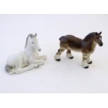 Two Russian model horses, a seated white foal and a brown shire horse. Marked under USSR. Largest