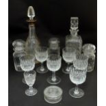 Two cut glass decanters, one with a hallmarked silver collar, together with wine glasses, lidded