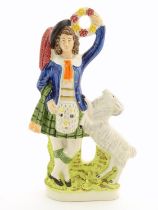 A Staffordshire pottery figure of a Highland man wearing a kilt with a sporran and a plume hat,
