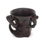 An Oriental cup of libation cup form with carved detail Please Note - we do not make reference to