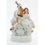 A Staffordshire flat back figural group depicting a Scottish highland couple with clock detail