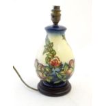 A Moorcroft style lamp base with tube lined decoration depicting flowers and foliate. Approx. 10 3/