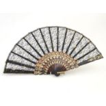 A late 20thC fan with black lace and gilt scrolling floral detail. Approx. 9" Please Note - we do