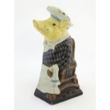 A 20thC cast doorstop / door porter modelled as a pig dressed as a seated pig. Approx. 12" high