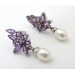 A pair of .925 silver drop earrings set with purple stones and pearl drops. Approx 1 1/4"long Please