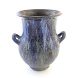 A studio pottery twin handled vase with a flared rim with a mottled blue glazed. Marked under.