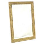 A 20thC gilt mirror with a decorative moulded edge. 23 1/2" wide x 34" high. Please Note - we do not