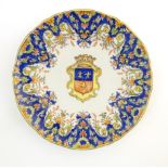 A Continental faience style plate with armorial crest to centre surmounted by a castle, with