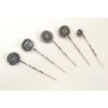 Five various white metal stick pins surmounted by impressed seal style decoration depicting Minerva,