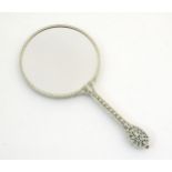 A 20thC double sided hand mirror with pierced floral and foliate decoration to handle. Approx. 11