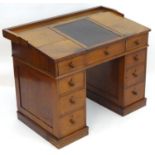 A Victorian mahogany clerks desk with a hinged writing slope above a twin pedestal base and four