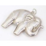 A white metal pendant formed as an elephant with silver hanging loop to top. Approx. 2 1/4" long