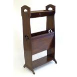 An early 20thC mahogany magazine rack with ebonised and satinwood inlay, having pierced decoration