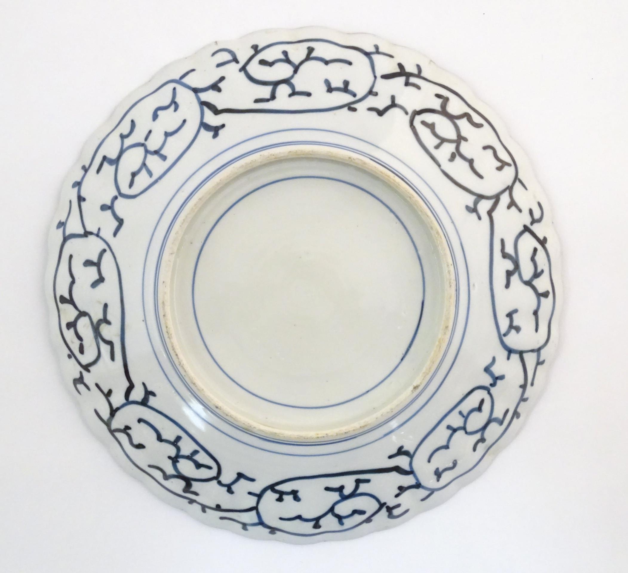 An Oriental charger with scalloped edge in the Imari palette decorated with a stylised censor on - Image 6 of 6