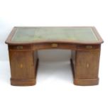 A late 19thC / early 20thC Jugend stil double pedestal mahogany desk, having a gold tooled leather