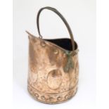 An Arts & Crafts cooper coal scuttle with swing handle and hammered decoration. Approx. 15 1/4" high
