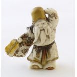 A Japanese carved model of a bearded man holding a fan, with gilt highlights. Approx. 2 3/8" high