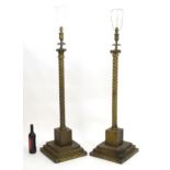 A pair of brass standard lamps formed as corinthian columns, with twist columns supported by stepped
