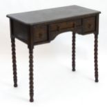 An early 20thC oak side table with a rectangular moulded top above small drawers and bobbin turned