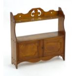 An early 20thC mahogany wall shelf / cupboard with a pierced top section, two panelled doors and a
