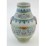 A Chinese famille verte vase with a bulbous body with twin ring mask handles, decorated with