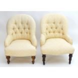 Two Victorian button back chairs with deep buttoned backrests and sprung seats, raised on turned