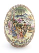 A Japanese model of an egg decorated with four ladies on a garden terrace playing musical