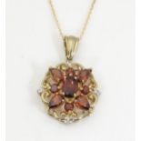A 9ct gold pendant set with diamonds and red stones on a 18" 9ct gold chain, pendant approx. 1" long