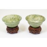 A pair of Chinese spinach jade bowls, with wooden stands. Cased. Bowls approx. 1 3/4" high x 4"