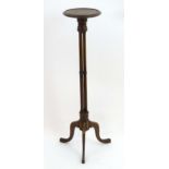 An early 20thC mahogany torchiere with a circular dished top above four turned supports and three