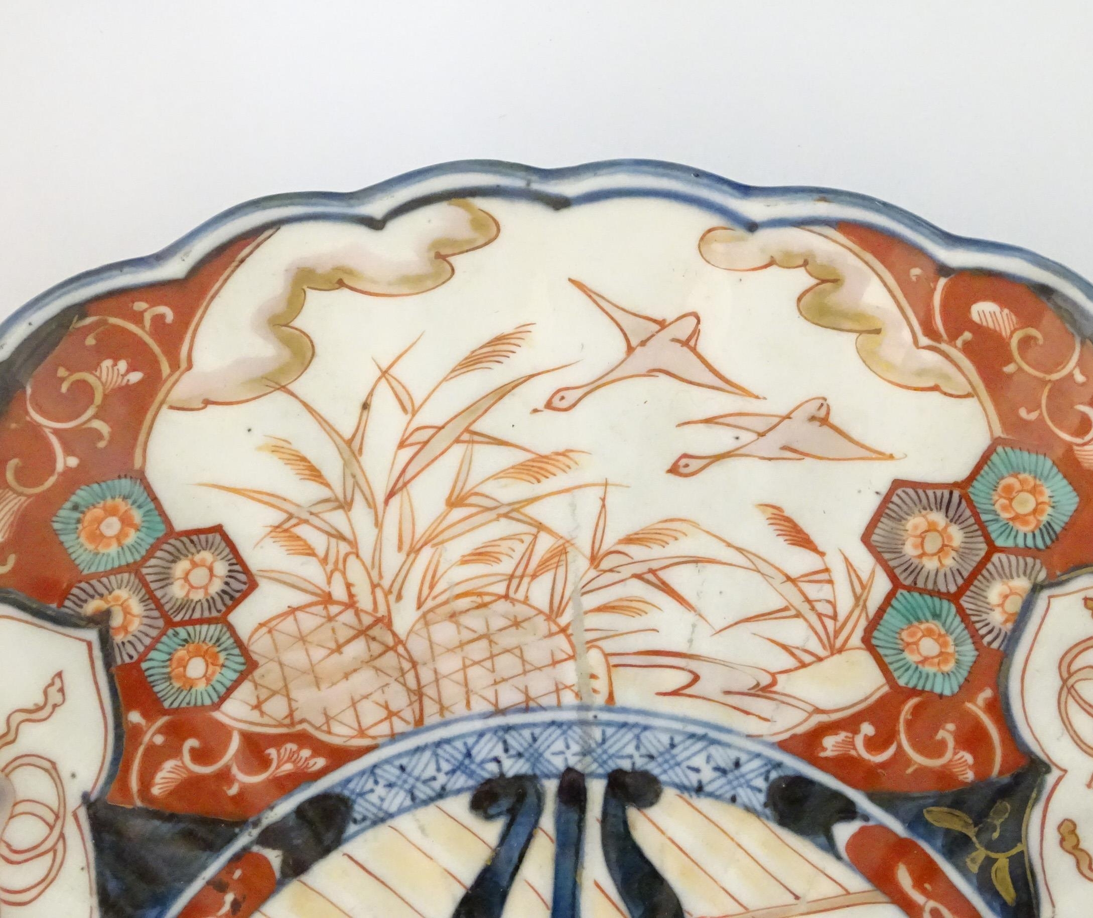 An Oriental charger with scalloped edge in the Imari palette decorated with a stylised censor on - Image 5 of 6