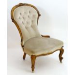 A late 19thC spoon back mahogany chair with a carved frame and deep buttoned upholstery above a
