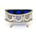 A silver salt with bowl and swag detail and blue glass liner, hallmarked Chester 1907 maker George