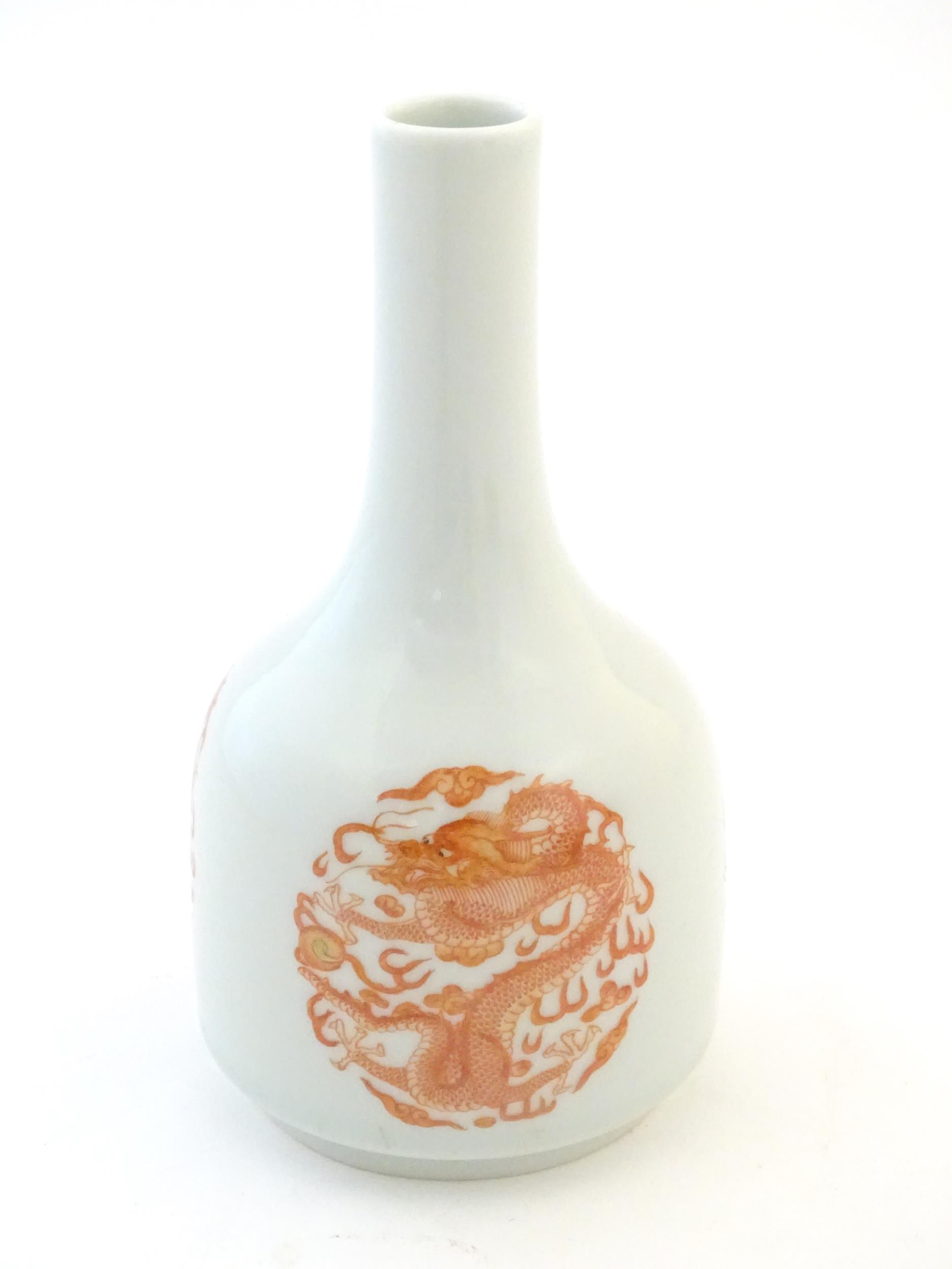 A Chinese bottle vase decorated with dragons and the flaming pearl amongst stylised clouds.