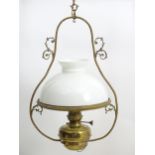 An early 20thC brass pendant light with white glass shade, the frame decorated with rope twists